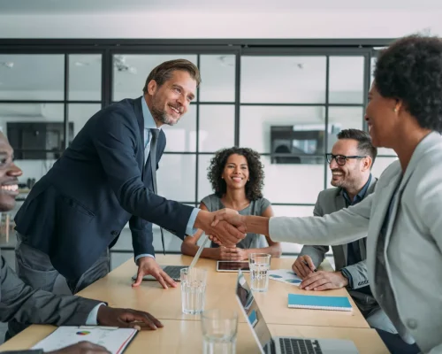 Businesspeople-Shaking-Hands-Across-Table-scaled-2